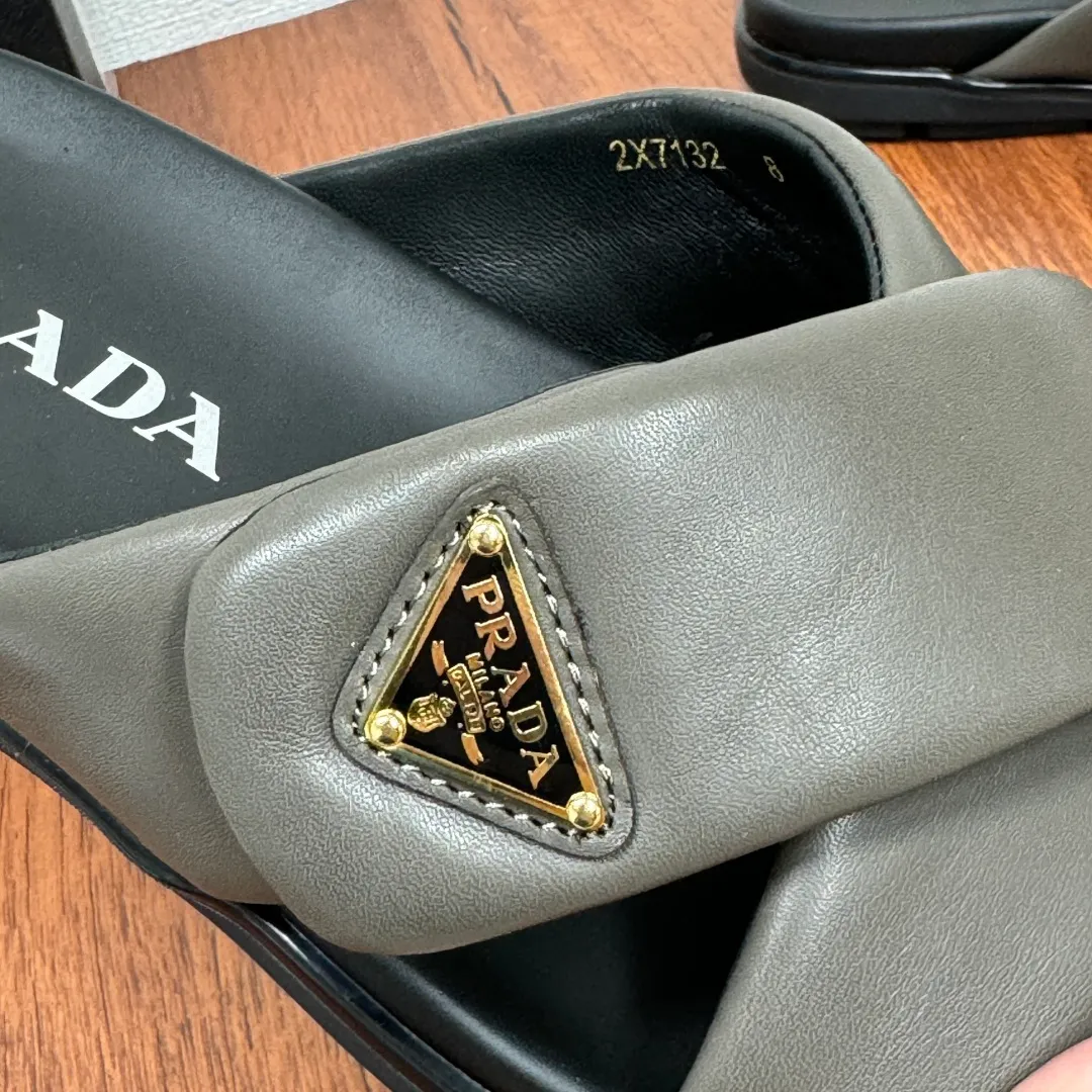 Batch 580 Prada/Prada's new men's leather cross slippers. Velcro closure can finely adjust the size. Calf leather light luxury slippers. Thick soft calf leather wraps the upper. Fat but soft rubber lazy style, soft and comfortable, excellent foot feel. Genuine leather bottom layer, cross style, with a Velcro closure buckle, easy to adjust the appropriate size, and a perfect fit for the wearing experience. The enamel gold triangle logo highlights the brand's classic features. Lightweight rubber thin sole, high foot comfort! Complete package! Size: 39-40-41-42-43-44-45 Leather shoe size Item number: 2X7132 Gray